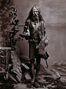 An Indian man wearing many beads, and carrying a begging bowl and an umbrella, in a..., c1900. Creator: Unknown