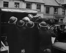An Injured Child Being Carried Into an Ambulance, 1940. Creator: British Pathe Ltd