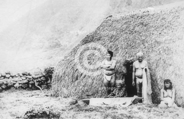 An old woman beating tapa in front of a pili grass house, Kalaupapa, Hawaii, 19th century. Artist: Unknown