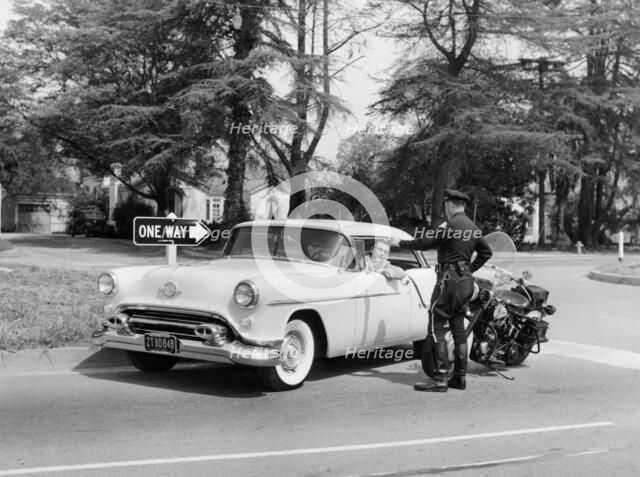 An Oldsmobile at the corner of an American street, 1954. Artist: Unknown