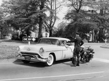 An Oldsmobile at the corner of an American street, 1954