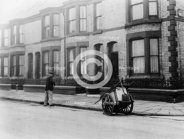 An 'Orderly Boy' and his cart sweeping a street, Liverpool, 1935. Artist: Unknown