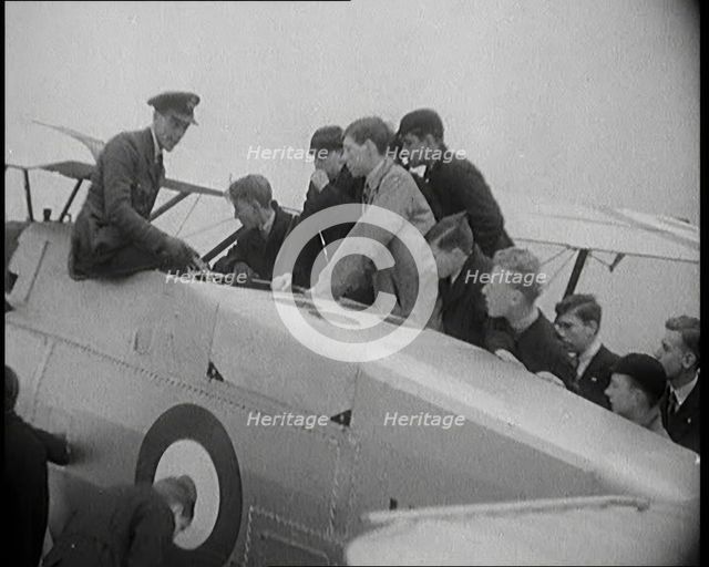 An RAF Officer Showing a Group of Male Children His Aeroplane, 1931. Creator: British Pathe Ltd.