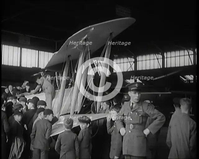 An RAF Officer Showing a Group of Male Children His Aeroplane, 1931. Creator: British Pathe Ltd.