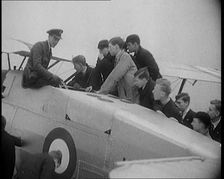 An RAF Officer Showing a Group of Male Children His Aeroplane, 1931. Creator: British Pathe Ltd