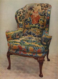 An upholstered armchair with wings, carved walnut frame and original silk needlework covering c17