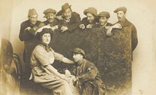 Actors gathered around a man in drag, between 1910 and 1919. Creator: Unknown