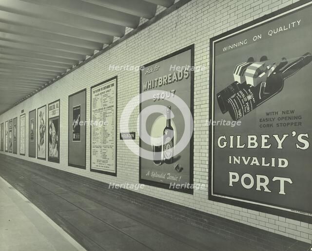 Advertisements for beer and port, Holborn Underground Tram Station, London, 1931. Artist: Unknown.