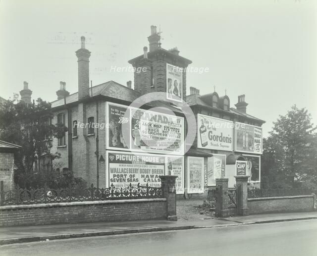 Advertising hoardings on the wall of a building, Wandsworth, London, 1938. Artist: Unknown.
