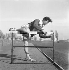 Adjusting a hurdle on an athletics track, Landskrona, Sweden, 1955. Creator: Unknown