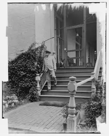 Admiral George Dewey on steps of house, Washington D.C., between 1890 and 1910. Creator: Levin Handy