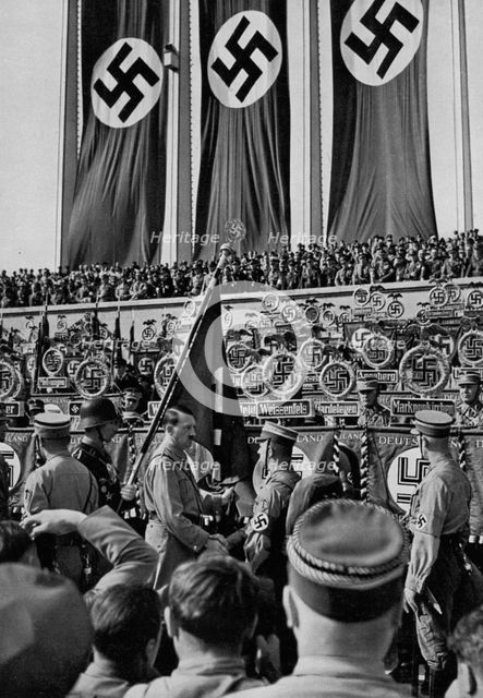 Adolf Hitler dedicates new standards, Nuremberg Rally, Germany, 1934. Artist: Unknown