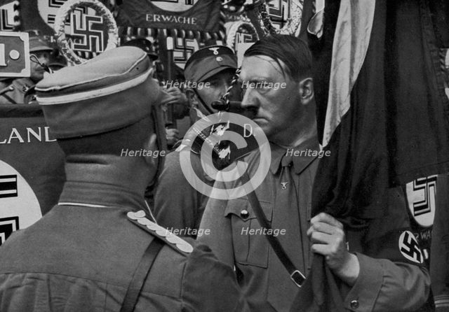 Adolf Hitler dedicating standards at the Nuremberg Rally, Germany, 1935. Artist: Unknown