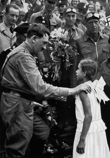 Adolf Hitler talking with a young girl during his election campaign, 1932