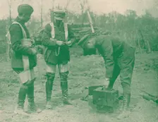 Aerial photographers fixing on parachute harnesses before making an ascent, c1917 (1919)