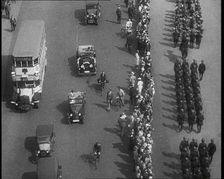 Aerial Shot of Soldiers Marching Down the Road in Front of a Crowd, 1933. Creator: British Pathe Ltd