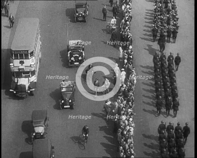 Aerial Shot of Soldiers Marching Down the Road in Front of a Crowd, 1933. Creator: British Pathe Ltd.