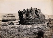 Africa: a group of African people standing on a kraal hut, between 1800 and 1899. Creator: Unknown
