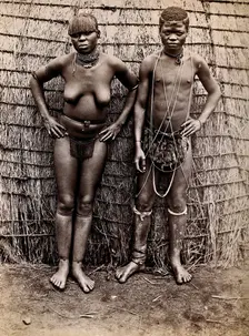 Africa: an African woman and man in front of a kraal hut, 19th century. Creator: Unknown