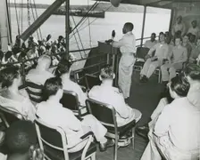 African American chaplain standing at the podium and conducting the religious service..., 1939 - 194 Creator: United States Coast Guard