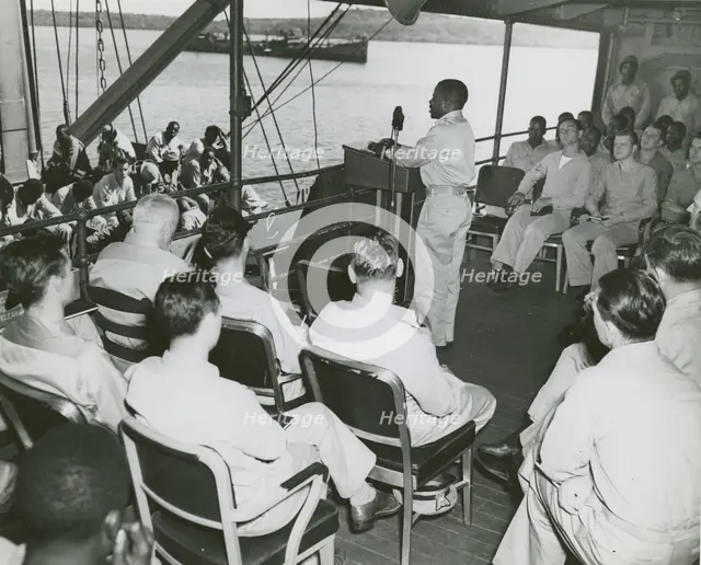 African American chaplain standing at the podium and conducting the religious service..., 1939 - 194 Creator: United States Coast Guard.