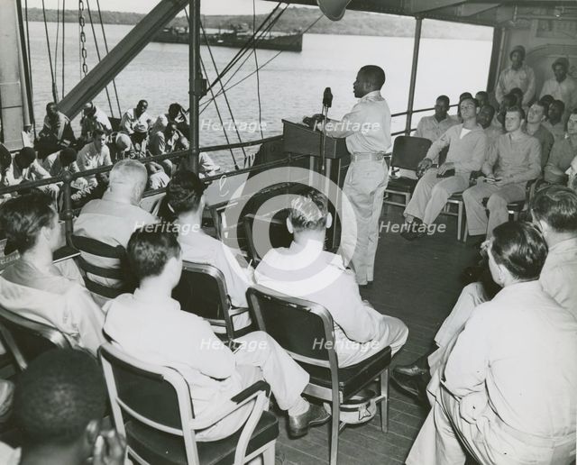 African American chaplain standing at the podium and conducting the religious service..., 1939 - 194 Creator: United States Coast Guard.