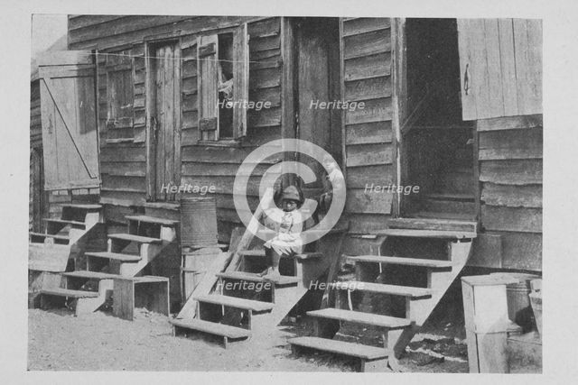 African American children sitting on the stairs in front of their house, 1922. Creator: Unknown.