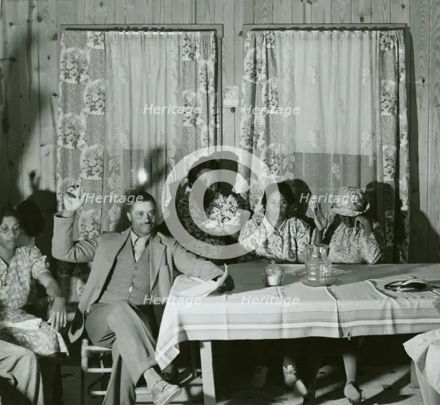 African American men and women sitting in attendance at a meeting to discuss farm..., May 1940. Creator: Farm Security Administration.