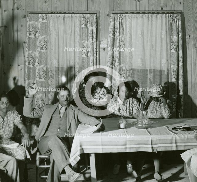African American men and women sitting in attendance at a meeting to discuss farm..., May 1940. Creator: Farm Security Administration.