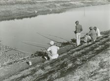African American migrant laborers fishing in Belle Glade, Florida, January 1939. Creators: Farm Security Administration, Marion Post Wolcott