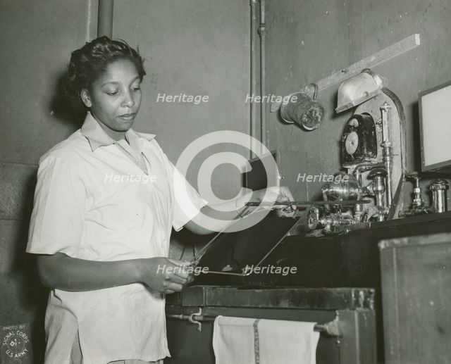 African American Private Hannah Wills developing an x-ray film in the x-ray laboratory..., 1943. Creator: Unknown.