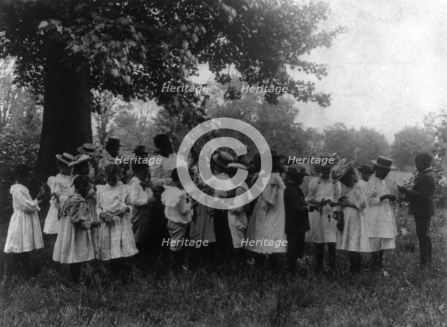 African American school children and teacher, studying leaves out of doors, (1899?). Creator: Frances Benjamin Johnston.