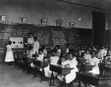 African American schoolgirls in classroom, learning to sew, (1899?). Creator: Frances Benjamin Johnston