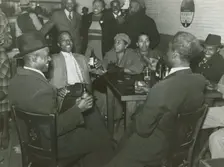 African Americans conversing and drinking beers in a bar, Clarksdale, Mississippi Delta, Nov 1939. Creators: Farm Security Administration, Marion Post Wolcott