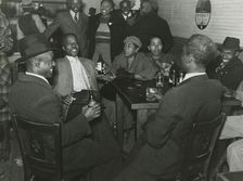 African Americans conversing and drinking beers in a bar, Clarksdale, Mississippi Delta, Nov 1939. Creators: Farm Security Administration, Marion Post Wolcott