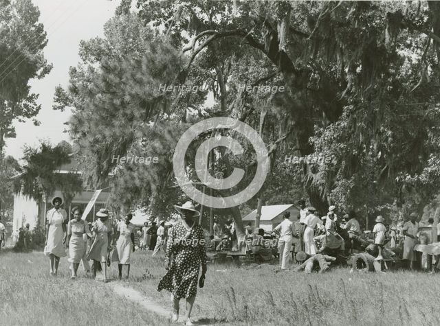 African Americans walking in an open field at a picnic, Beaufort, South Carolina, July 4, 1939. Creators: Farm Security Administration, Marion Post Wolcott.