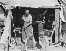 Aged woman with three of her twenty-two grandchildren, Kern county migrant camp, California, 1936. Creator: Dorothea Lange