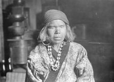 Ainu woman wearing a headscarf, earrings, and a necklace, 1908. Creator: Arnold Genthe
