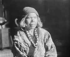 Ainu woman wearing a headscarf, earrings, and a necklace, 1908. Creator: Arnold Genthe