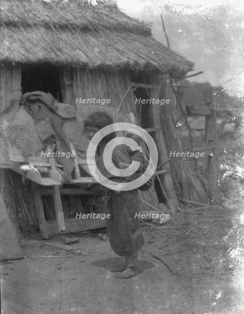 Ainu child carrying a baby on back, 1908. Creator: Arnold Genthe.