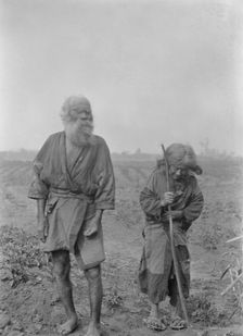 Ainu man and woman standing outside, 1908. Creator: Arnold Genthe