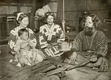 Ainu Man and Women at Home 1910. Creator: Herbert Ponting