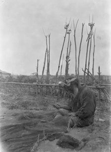 Ainu seated outside working on nets, 1908. Creator: Arnold Genthe