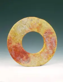 Altered jade bi-disc with russet patches, Neolithic, Liangzhu culture, China, c3400-c2250 BC. Creator: Unknown