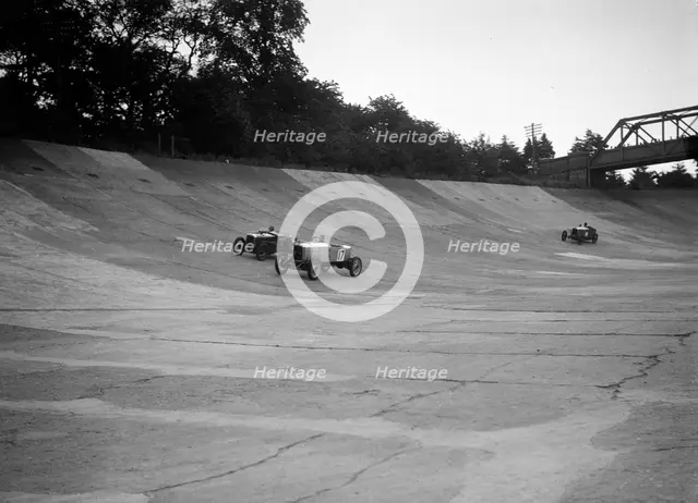 Alvis 17 and Austin 747 cc racing on the banking at Brooklands. Artist: Bill Brunell.