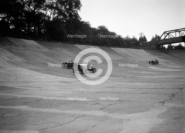 Alvis 17 and Austin 747 cc racing on the banking at Brooklands. Artist: Bill Brunell.