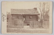 Albumen print of a woman and two children in front of a log house in Georgia, 1880s. Creator: H. S. Clark