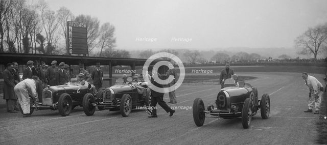 Alfa Romeo and two Bugatti Type 35s on the start line, Donington Park, Leicestershire, 1935. Artist: Bill Brunell.