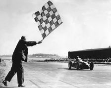 Alfa Romeo, Giuseppe Farina takes chequered flag, British Grand Prix at Silverstone 1950. Creator: Unknown