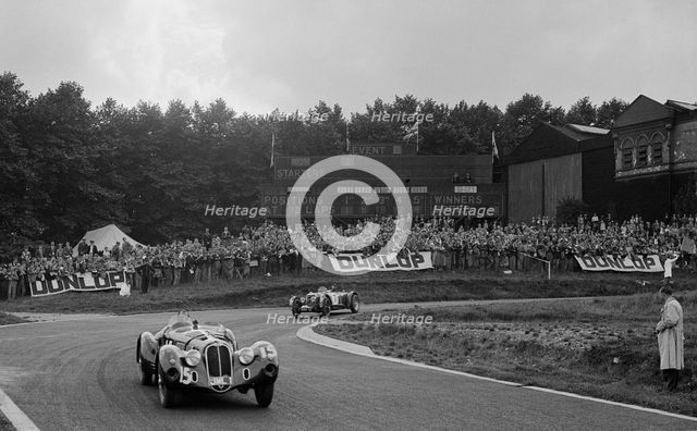 Alfa Romeo of Hugh Hunter leading a Riley at Crystal Palace, London, 1939. Artist: Bill Brunell.